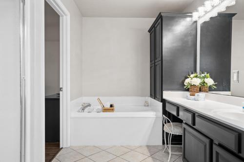 a bathroom with a tub and a sink and a bath tub at Pool, Hot Tub, Game Room & Sleeps 18! By StayLage in Hot Springs
