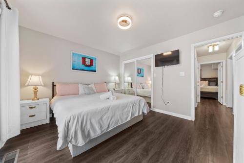 a white bedroom with a large bed and a television at Pool, Hot Tub, Game Room & Sleeps 18! By StayLage in Hot Springs
