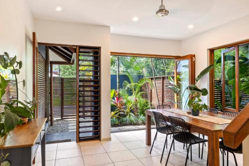 an open dining room with a wooden table and chairs at The Savannah Villa in Port Douglas