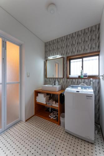 a bathroom with a sink and a mirror at 金澤華ゆり in Kanazawa
