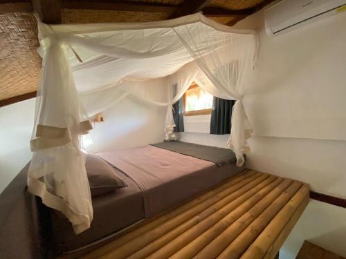a bedroom with a bed with a canopy at Studio On Air in Gili Islands