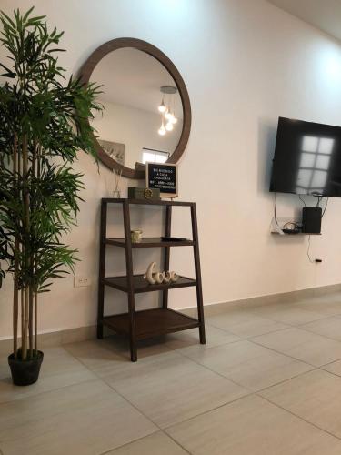 a mirror in a room with a shelf and a tv at Casa Punta Arena in Los Bledales
