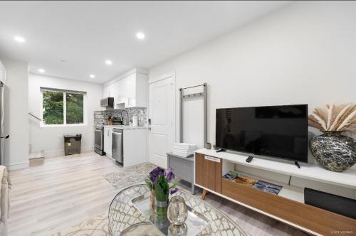 a living room with a large flat screen tv at Entire new small home in Vancouver