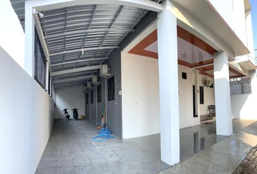 an empty hallway of a building with a wooden ceiling at Kusuma Raya Guest House in Srondolwetan