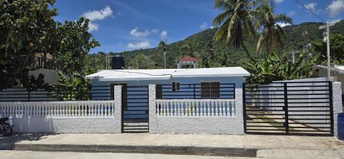 a blue and white fence with a white gate at Villa el real los patos in Los Patos