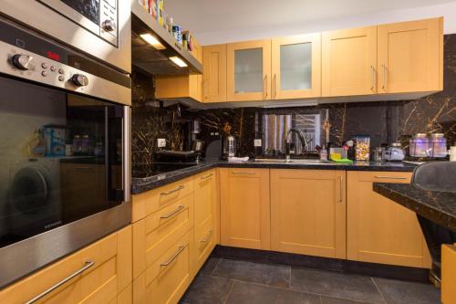 a large kitchen with wooden cabinets and a sink at Villa bella in Mali Lošinj