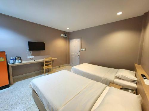 a hotel room with two beds and a desk at The Fifth Residence in Bangkok