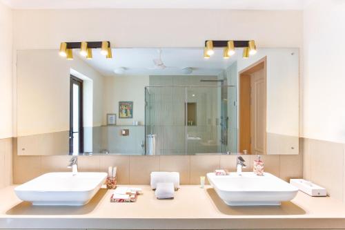 a bathroom with two sinks and a large mirror at Melhor Stays villas - L-M304 Luxurious 3BHK villa with private pool, Anjuna in Anjuna
