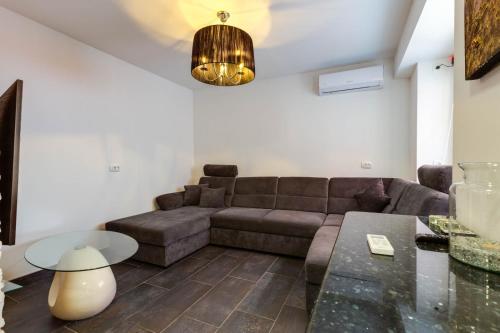 a living room with a couch and a table at Villa bella in Mali Lošinj