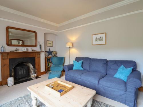 a living room with a blue couch and a table at 5 Belmont Terrace in Beer