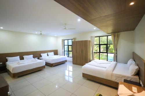 a bedroom with two beds and a large window at J S Grand in Yelagiri