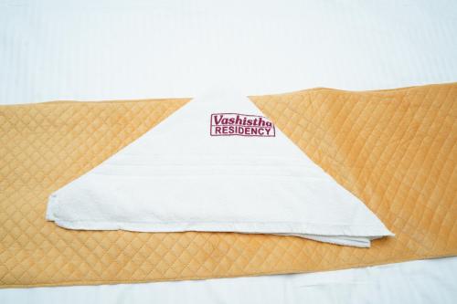 a pillow on a bed with a towel on it at Vashistha Residency in Bhadrāchalam