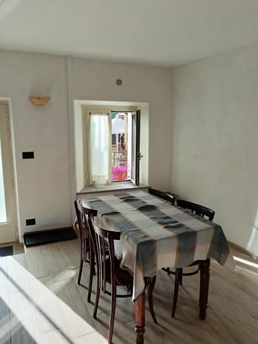 a dining room with a table and chairs and a window at Come una barca nel bosco in Villar Perosa