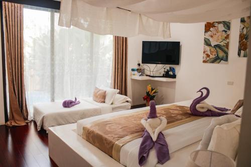a hotel room with two beds with swans on them at Carpe Diem Villas & Resort in Puerto Princesa City
