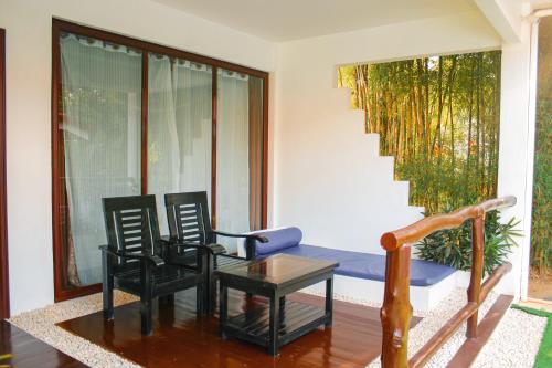 a living room with chairs and a table and a staircase at Carpe Diem Villas & Resort in Puerto Princesa City