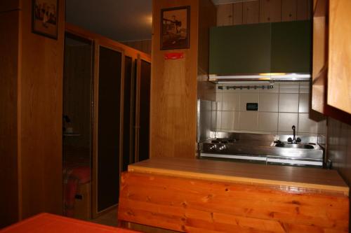 eine Küche mit einer Theke mit einer Spüle und einem Herd in der Unterkunft Appartamento Amba 39 in Mezzana