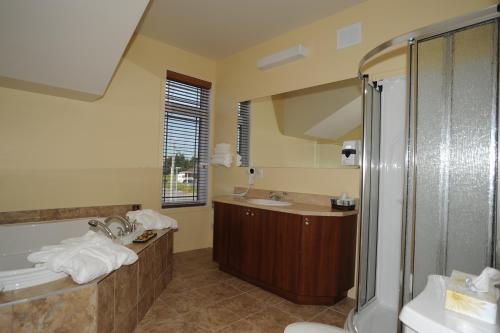 La salle de bains est pourvue de 2 lavabos et d'une douche. dans l'établissement Hotel La Porte de la Matawinie -Hôtel Matha, à Saint-Jean-de-Matha
