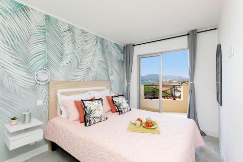 a bedroom with a bed with a large window at ON VACAY - Votre havre de paix à 100 m des plages in Cannes
