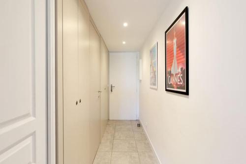 a hallway with a white door and a painting on the wall at ON VACAY - Votre havre de paix à 100 m des plages in Cannes