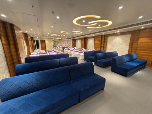 a waiting room with blue couches and chairs in a building at Hotel Anju Shree Inn-Near Jaipur Airport Terminal 1 in Jaipur
