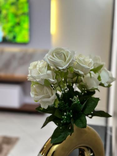 a yellow vase with white flowers in it at Livluxe Apartments 7 in Kampala