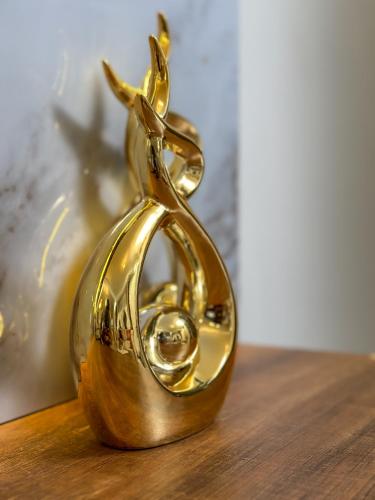a pair of gold scissors sitting on top of a table at Livluxe Apartments 7 in Kampala