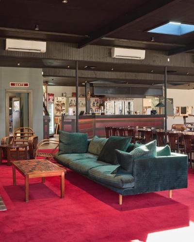 a living room with a green couch and a table at Alpine Inn in Khancoban