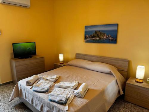 a bedroom with a bed with towels on it at MF House in Taormina