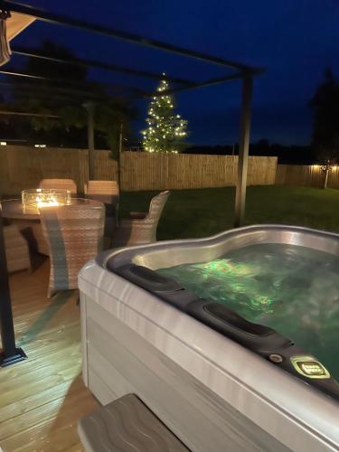 a hot tub in a backyard at night at Wisteria Barn hot tub holidays in the Cotswolds in Badsey
