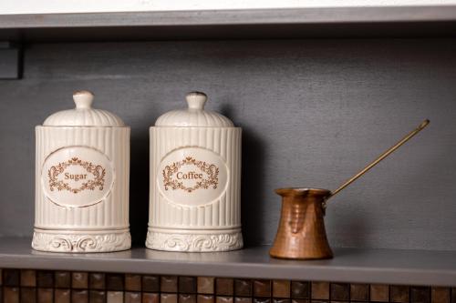 two white vases sitting on a shelf next to a vase at Uva Nera House Oia in Oia