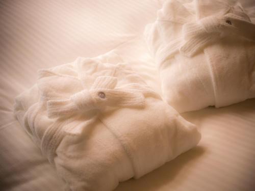 two white croissants sitting on a bed at Asan Kotonami in Manno