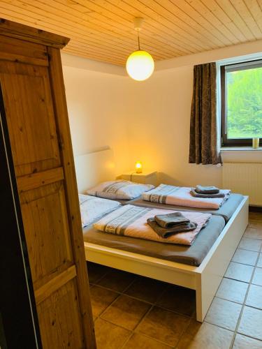 a bedroom with a bed with a wooden ceiling at Ferienwohnung Losenberg in Olsberg