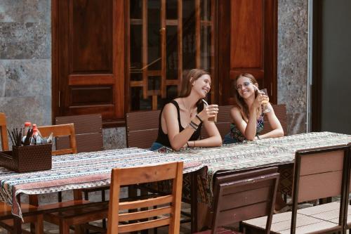 two women sitting at a table talking on cell phones at The Hill Villas in Phong Nha