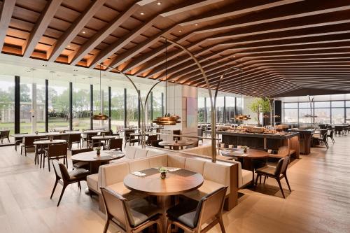 een restaurant met tafels, stoelen en ramen bij Le Meridien Hualien Resort in Hualien