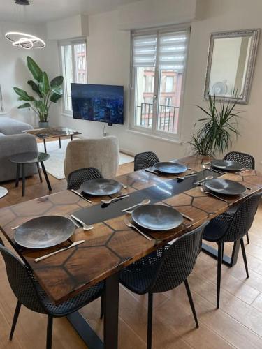 une table en bois avec des assiettes et des ustensiles dessus dans l'établissement 90m2 hyper centre Sauna, à Strasbourg