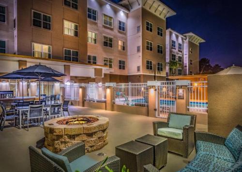a patio with a fire pit and chairs and a building at Residence Inn by Marriott Savannah Airport in Savannah