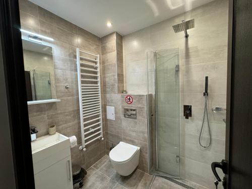 a bathroom with a toilet and a glass shower at Къща за гости Лъките in Divchovoto