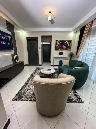 a living room with two chairs and a couch at Livluxe Apartments 6 in Kampala