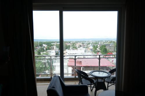 a room with a large window with chairs and a table at The Emerald Grand in Dehradun