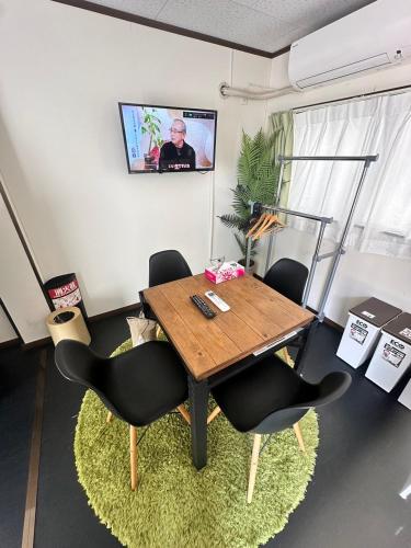 a table and chairs in a room with a tv at CH Maezato in Ishigaki Island