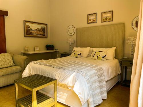 a bedroom with a bed and a couch at Telestai Guest House in White River