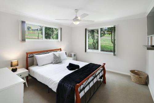 a bedroom with a bed and two windows at Dawn Retreat in Bonnie Doon