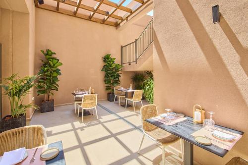 a patio with tables and chairs in a restaurant at Paralos Venus Suites Adults Only in Hersonissos