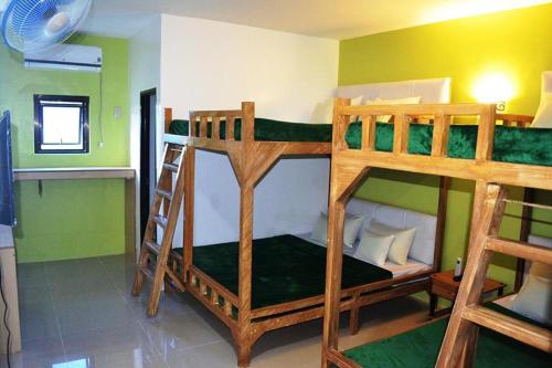two bunk beds in a room with green walls at Casa Del Camba Hotel and Restaurant near Hundred Islands in Alaminos