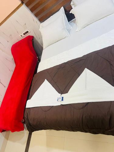 un primo piano di un letto con una coperta rossa di Town Gate Dream Palace International a Kovalam
