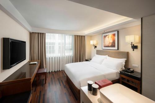 a hotel room with a bed and a flat screen tv at SSAW Boutique Hotel Sanya in Sanya