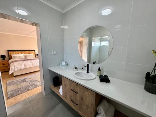 a bathroom with a sink and a mirror and a bed at The Starling Room in East London