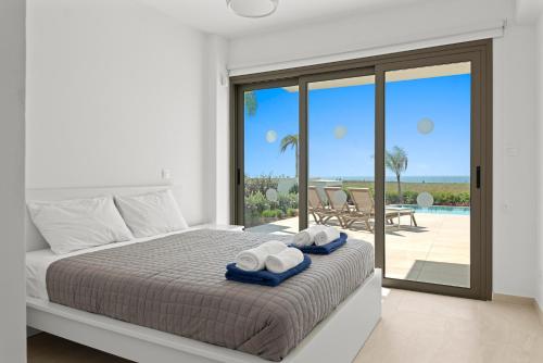 a bedroom with a bed and a view of the ocean at Serenity Waves Villa 6 in Sophtadhes