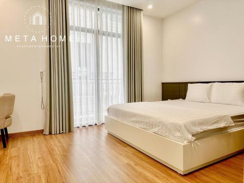a bedroom with a bed and a large window at V-Homestay in Hai Phong