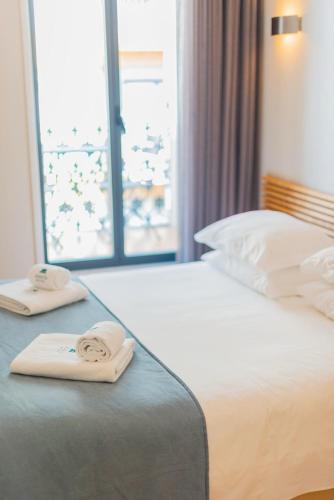 a hotel room with a bed with two towels on it at Boavista Guest House in Porto